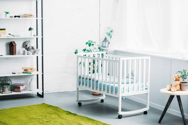 Interior of modern light childrens room with crib — Stock Photo
