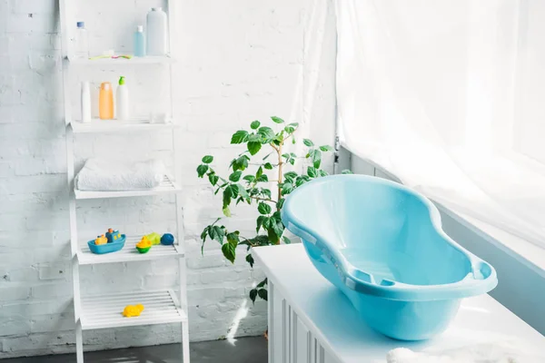 Пластиковая ванна для детей на стенде в белом современном номере — стоковое фото