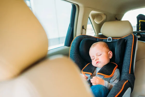 Adorable little baby sleeping in child safety seat in car — Stock Photo