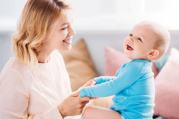 Schöne Mutter hat Spaß mit lachendem Kind zu Hause — Stockfoto