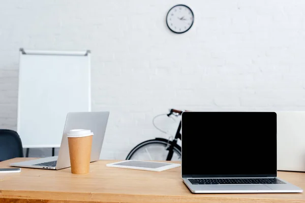 Laptops, digital tablet and coffee to go on table in office — Stock Photo