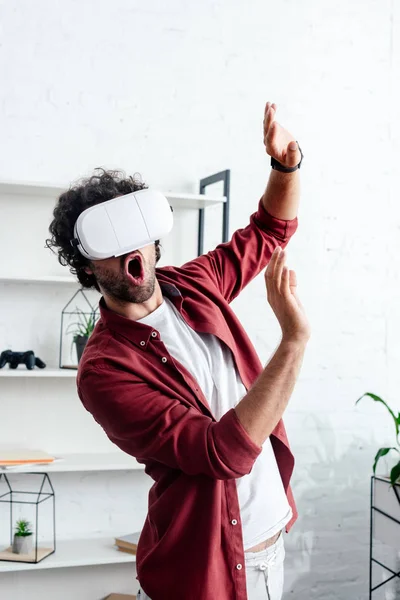 Excited young man using virtual reality headset in office — Stock Photo