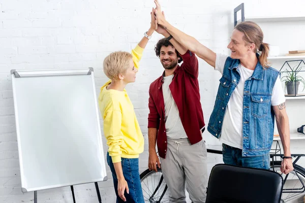 Young start up team giving high five while working together neat whiteboard — Stock Photo