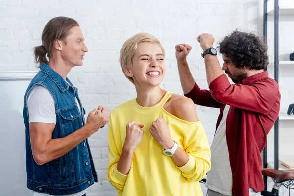 Happy young business team triumphing in office — Stock Photo