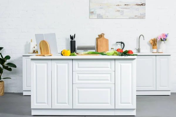 Спелые овощи на кухонном столе в современной светлой кухне — стоковое фото