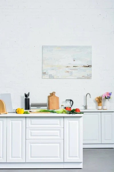 Pimientos y cebolla verde en el mostrador de la cocina en la cocina moderna luz - foto de stock