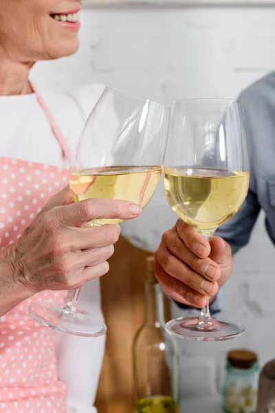 Recortado tiro de elederly pareja tintineo vasos de vino - foto de stock