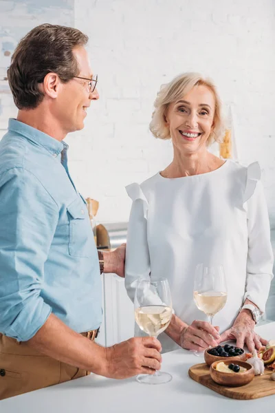 Feliz pareja de ancianos beber vino juntos en casa - foto de stock