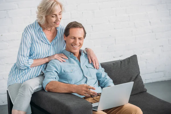 Hochwinkelaufnahme eines lächelnden Senioren-Paares, das gemeinsam Laptop benutzt — Stockfoto
