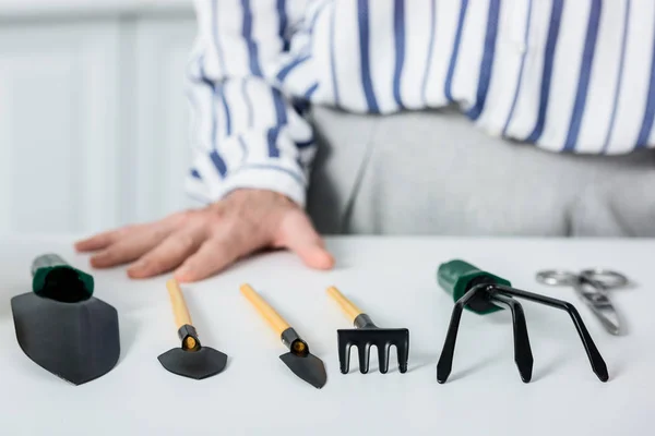 Cropped shot of senior woman and small gardening tools — Stock Photo