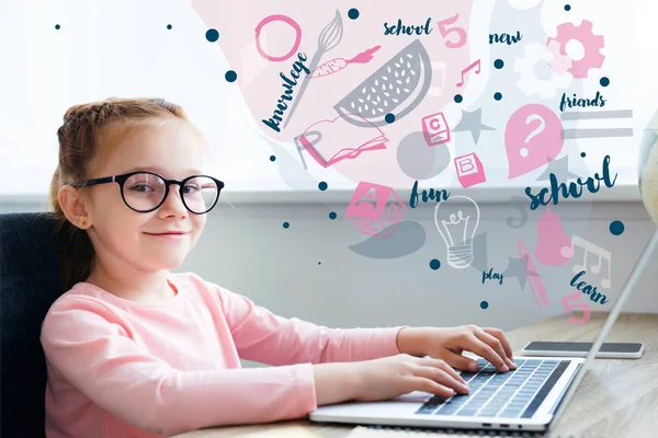 Hermoso niño en gafas con portátil con iconos educativos - foto de stock