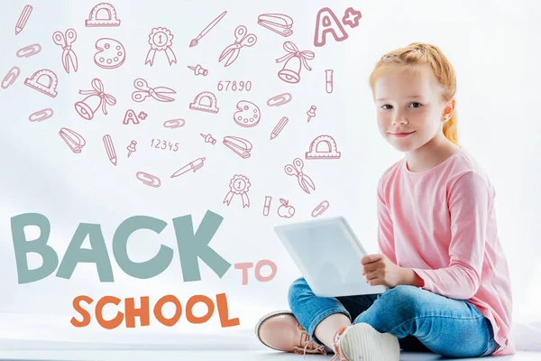 Belle rousse enfant à l'aide d'une tablette numérique, avec icônes et concept de retour à l'école — Photo de stock