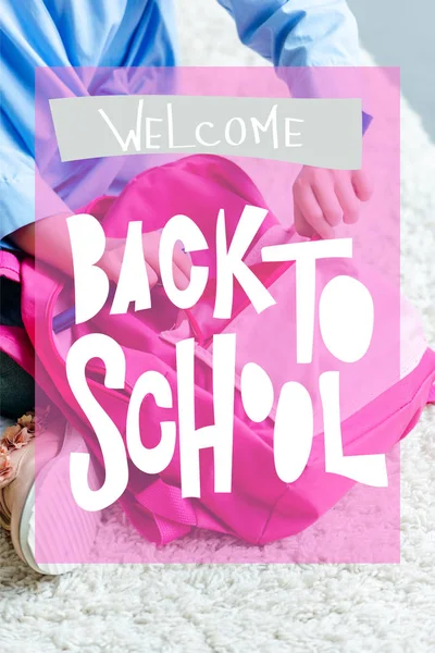 Recortado tiro de niño embalaje rosa bolsa de la escuela en casa, bienvenido de nuevo al concepto de la escuela - foto de stock