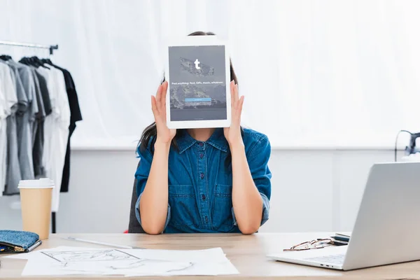Giovane donna che copre il viso da tablet digitale con sito tumblr sullo schermo — Foto stock