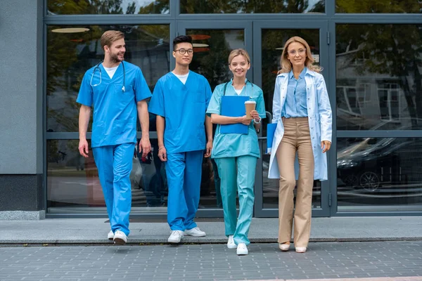 Enseignant marchant avec des étudiants multiculturels à l'université de médecine — Photo de stock