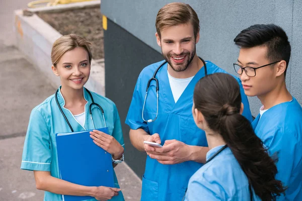 Vista de ángulo alto de los estudiantes de medicina multicultural de pie cerca de la universidad médica - foto de stock