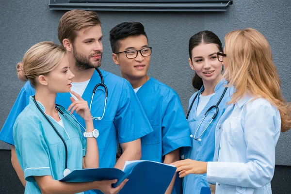 Estudiantes multiculturales pensativos mirando al profesor en la universidad médica - foto de stock