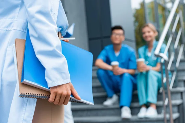 Image recadrée du médecin tenant des dossiers avec des documents — Photo de stock