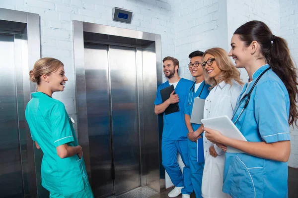 Professor com alunos multiculturais esperando elevador na universidade de medicina — Fotografia de Stock