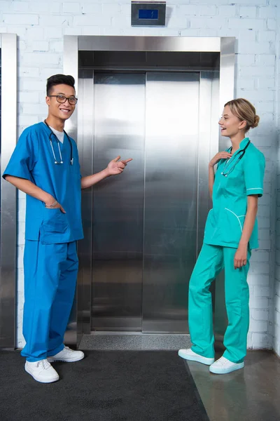 Estudiantes de medicina multiculturales felices esperando ascensor en la universidad - foto de stock