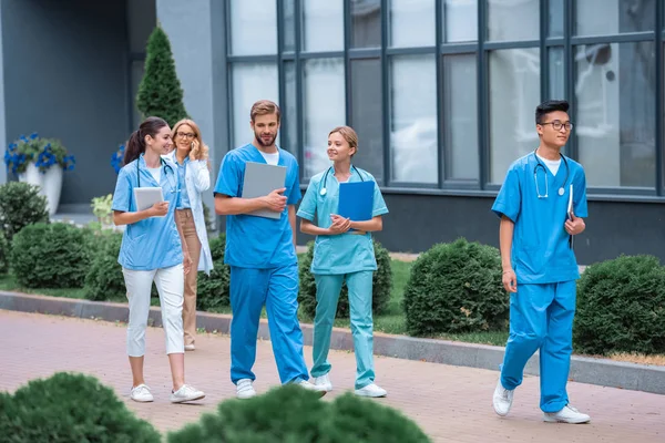 Lehrer und multiethnische Studenten zu Fuß auf der Straße in der Nähe der medizinischen Universität — Stockfoto