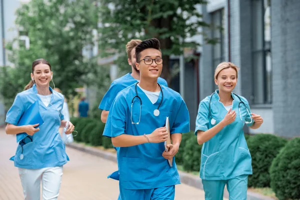 Studenti multietnici che corrono vicino all'università medica — Foto stock