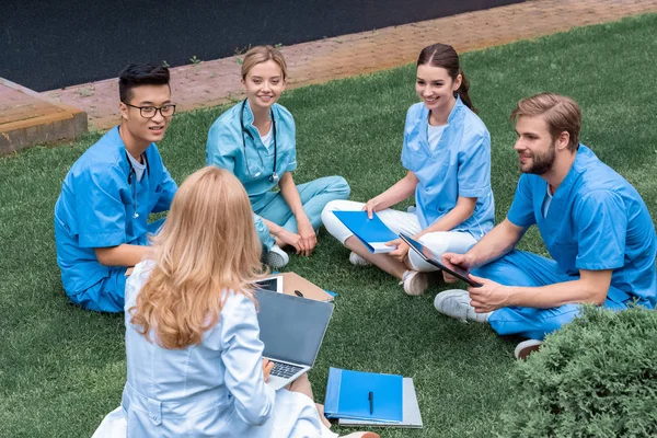 Teacher having lesson with multicultural students at medical university on green grass — Stock Photo