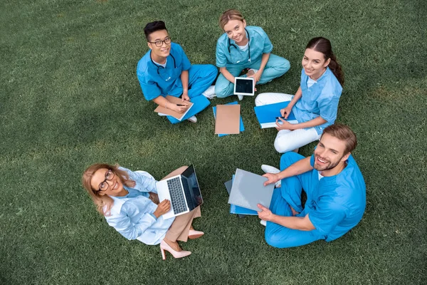 Vista aerea di insegnante che ha lezione con gli studenti multiculturali presso l'università medica su erba verde — Foto stock
