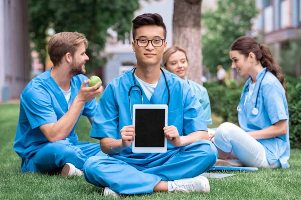 Guapo asiático médico estudiante celebración tableta con blanco pantalla - foto de stock