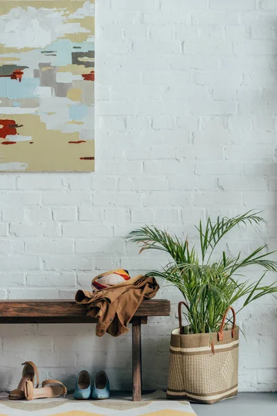 Chaussures différentes sous banc en bois dans le couloir moderne à la maison — Photo de stock