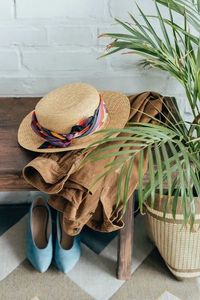 Straw hat and jacket on wooden bench in corridor — Stock Photo