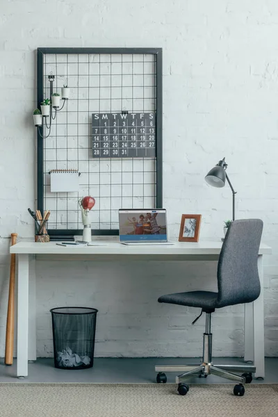 Laptop mit geladener Couchsurfing-Seite auf dem Tisch im modernen Büro — Stockfoto