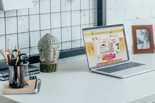 Ноутбук с загруженной страницей aliexpress на столе в современном офисе — стоковое фото