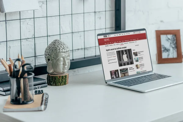 Laptop with loaded bbc news page on table in modern office — Stock Photo