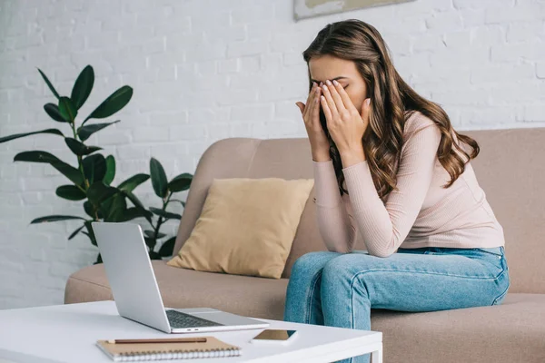 Young woman with pain in eyes and headache working with laptop at home — Stock Photo