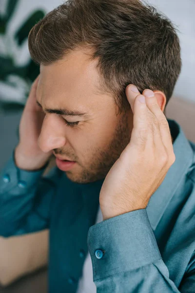 Vista de cerca del joven que sufre de dolor de cabeza - foto de stock