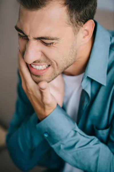 Крупный план молодого человека, страдающего зубной болью — стоковое фото