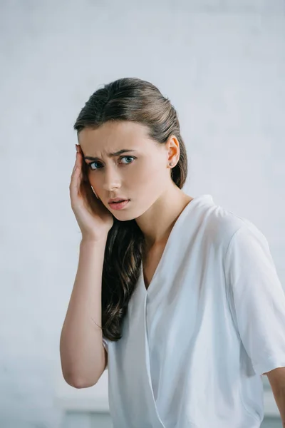 Junge Geschäftsfrau leidet unter Kopfschmerzen und blickt in die Kamera — Stockfoto