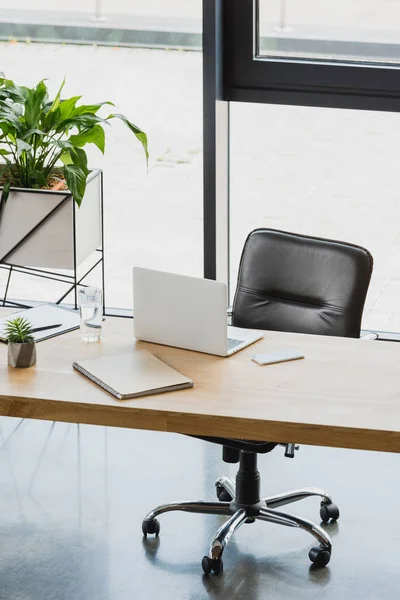 Laptop e smartphone na mesa de madeira no escritório moderno — Fotografia de Stock