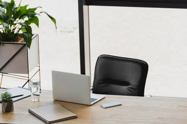 Ноутбук і смартфон на дерев'яному столі в сучасному офісі — стокове фото