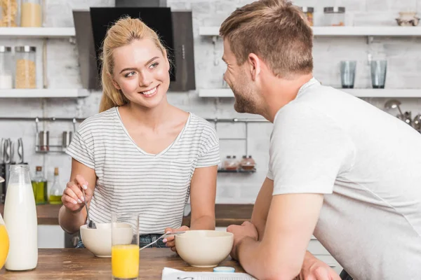 Casal tomando café da manhã na cozinha e olhando um para o outro — Fotografia de Stock