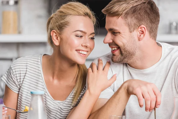 Smiling couple hugging during breakfast in kitchen — Stock Photo