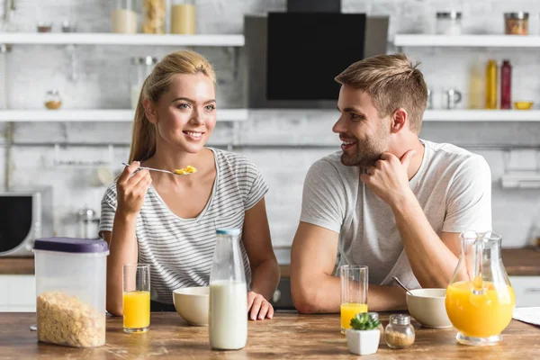 Pareja alegre desayunando sano en la cocina - foto de stock