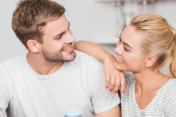 Retrato de pareja feliz mirándose en la cocina - foto de stock