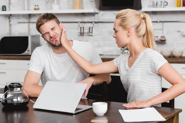 Young woman slapping boyfriend during quarrel at home — Stock Photo