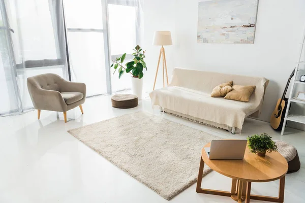 Интерьер современной гостиной с ноутбуком, ковром и мебелью — стоковое фото