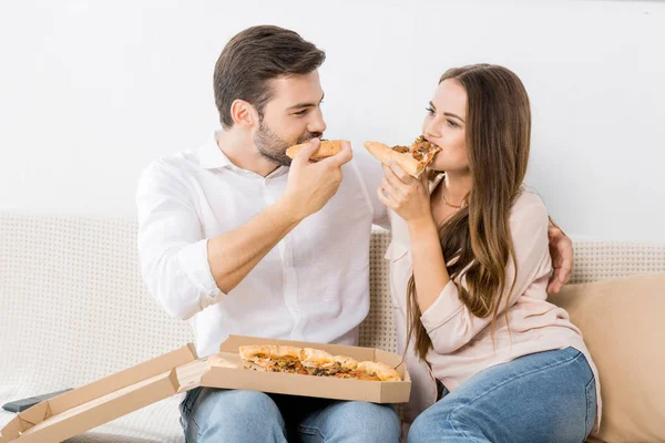 Porträt eines jungen Paares, das zu Hause Pizza isst — Stockfoto