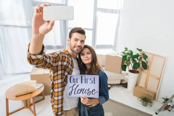 Porträt eines jungen Paares mit unserer ersten Hauskarte, die Selfie auf dem Smartphone macht und nach Hause zieht — Stockfoto