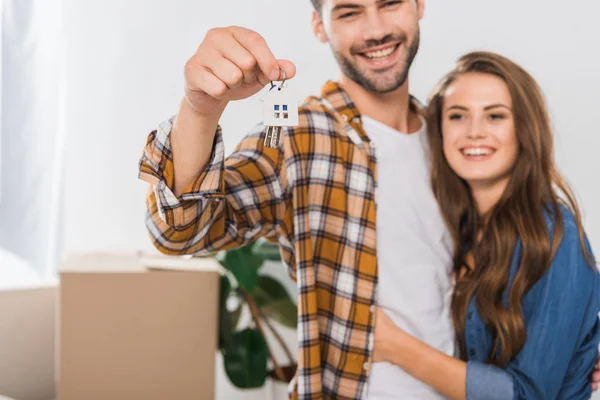 Foco seletivo de casal feliz com chaves da nova casa — Fotografia de Stock