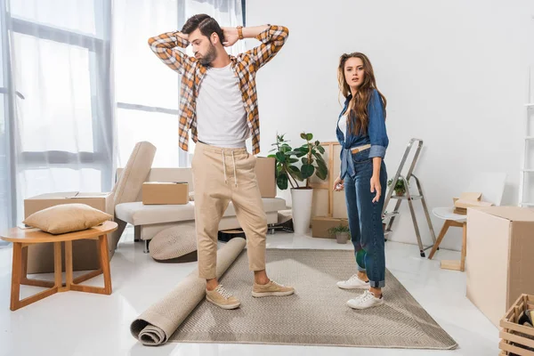 Confuso giovane coppia a nuova casa con scatole di cartone, trasferirsi concetto di casa — Foto stock